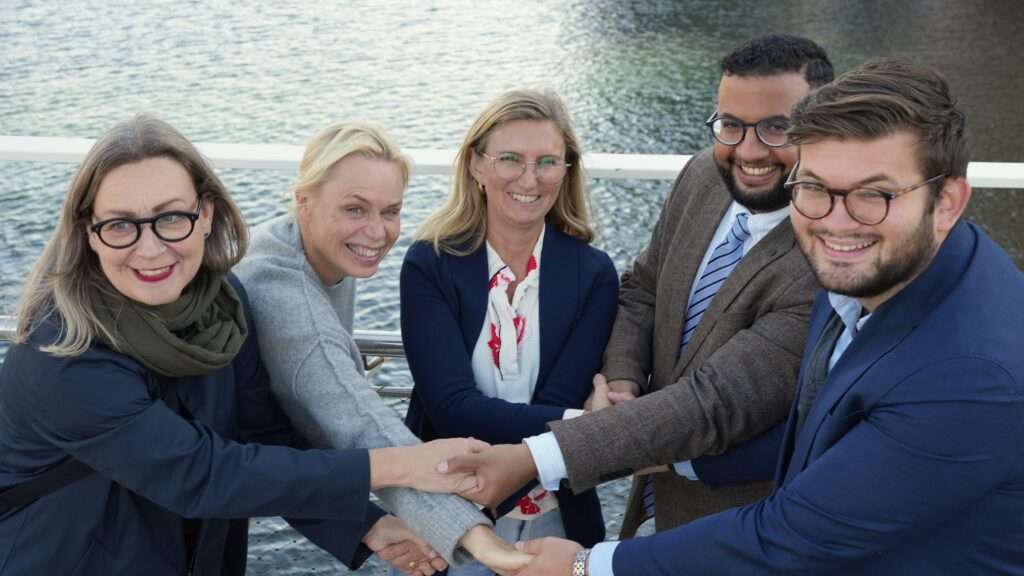 Charlotte G Brynielsson, hållbarhetsstrateg Viable Cities, Ebba Willerström-Ehrning, projektledare Fossilfritt Sverige, Camilla Byström, programchef Infrasweden samt kommunalråden Amir Jawad (L, miljönämndens ordförande) och Alexander Svensson (M, stadsbyggnadsnämndens ordförande) i Helsingborg. Dessa tar i varandras händer och signalerar att de är enade framåt i arbetet för utsläppsfria entreprenadmaskiner.