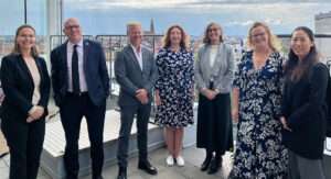 UN-Habitats generaldirektör Anacláudia Rossbach omges av Olga Kordas och Åsa Minoz, samt Olle Dierks i programteamet. I Dyfed Aubrey, chef för UN-Habitats Brysselkontor, Åsa Jonsson, chef för Global Water Operators’ Partnerships Alliance samt ⁠Xuesai Ma vid enheten för strategiska partnerskap står alla tillsammans på takterassen på Viable Cities kontor med utsikt över Stockholms innerstad.